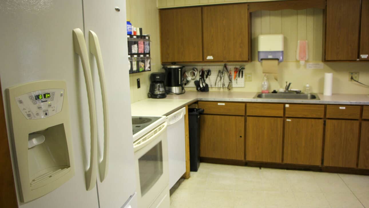 A white refrigerator in a summer camp kitchen in Iowa.