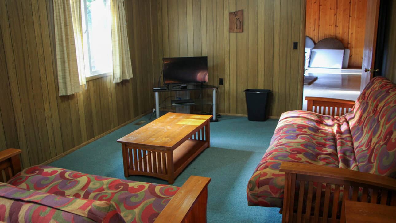 A summer camp living room with couches and a table in Iowa.